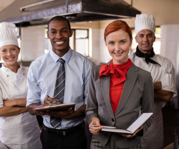 Group of hotel staffs standing in kitchen at hotel